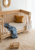 Natural Linen Cot Sheet with a Lake Blue swaddle draped over the cot 